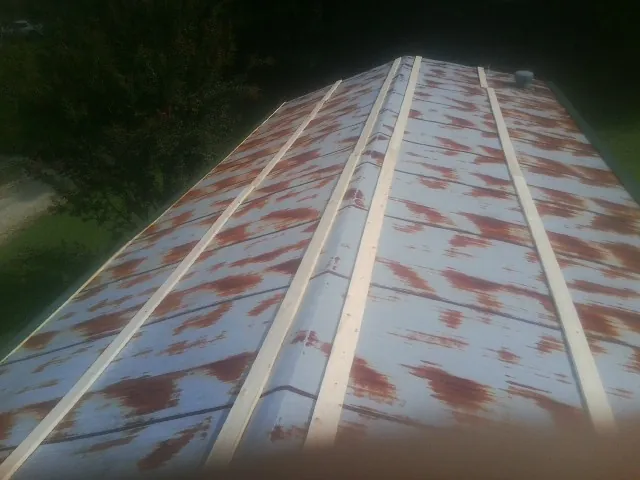 Rusted metal roof panels with new wood purlins before replacement — Storm Damage Roof Repair in Babson Park by Roofing Brothers
